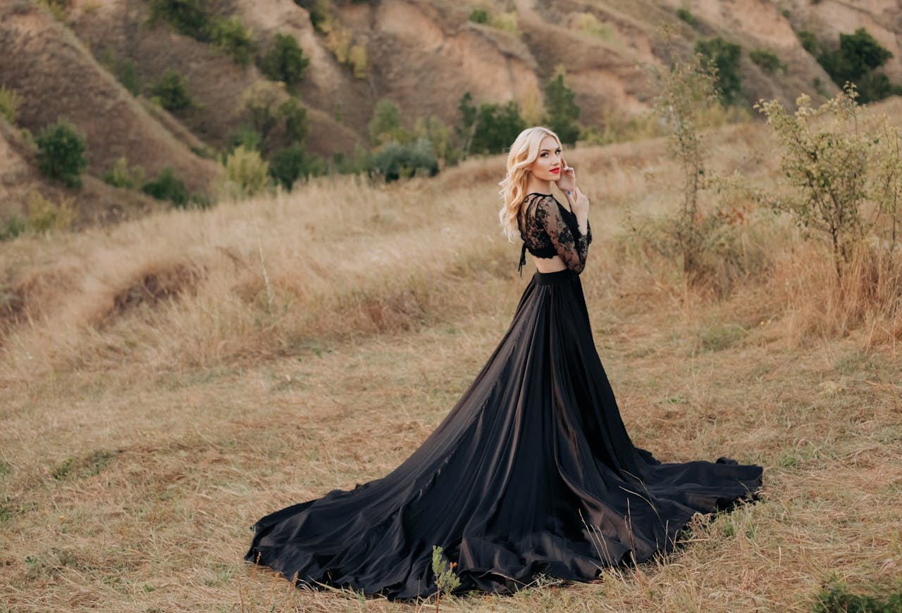 creative-03 Blonde woman in a black maxi dress poses gracefully in a rural meadow in Dnipro, Ukraine.